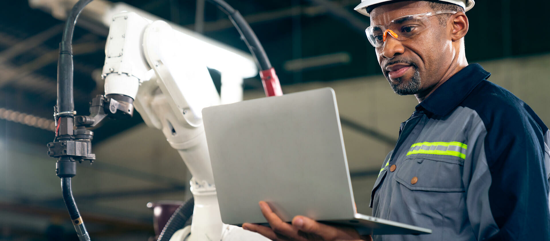 trabalhador industrial consultando notebook